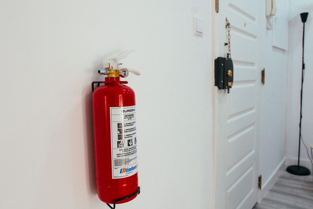 Fire extinguisher mounted on a wall, used as a representative image for PG hostel fire safety compliance in Pune.